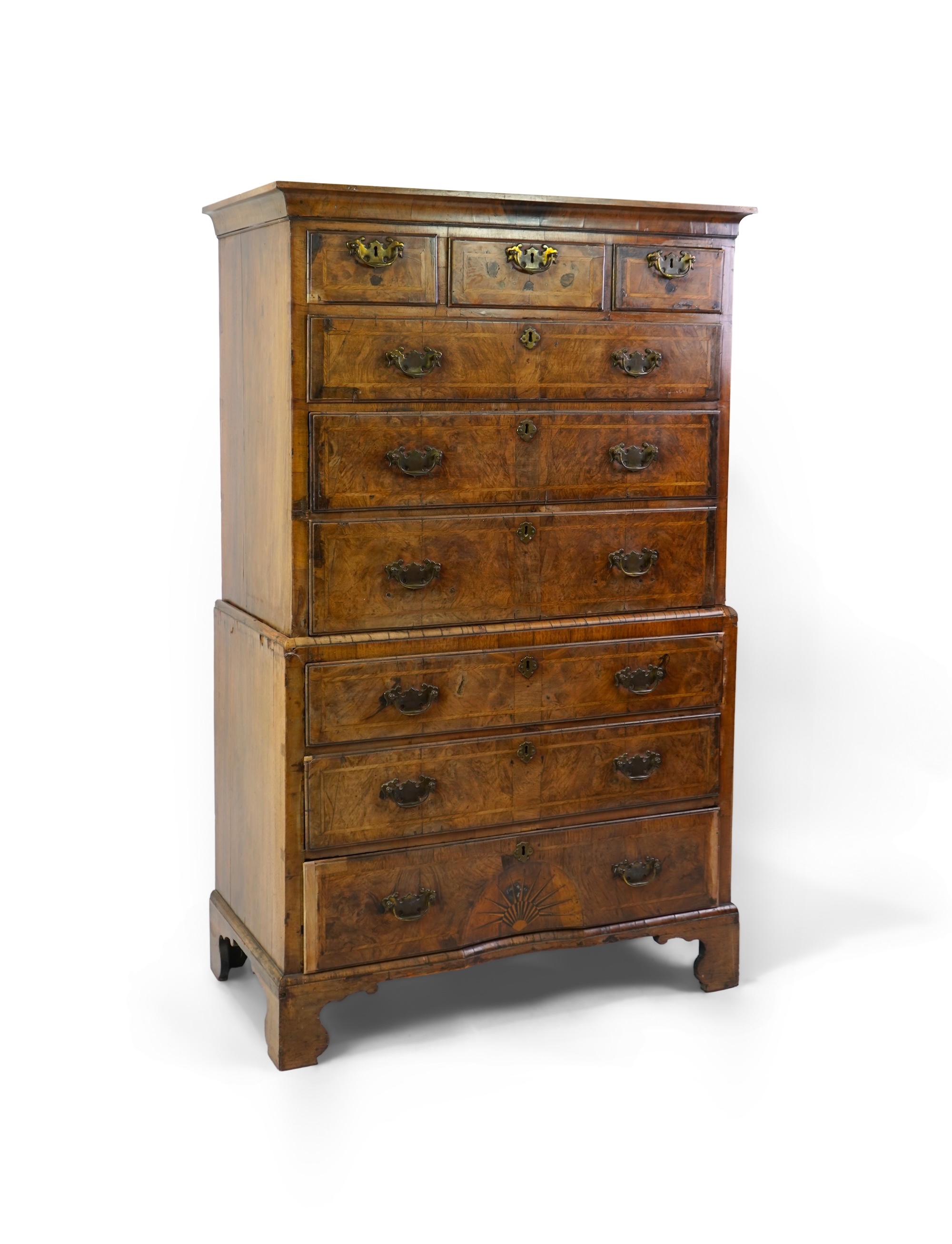 A George I feather banded, concave inlaid starburst walnut chest on chest
